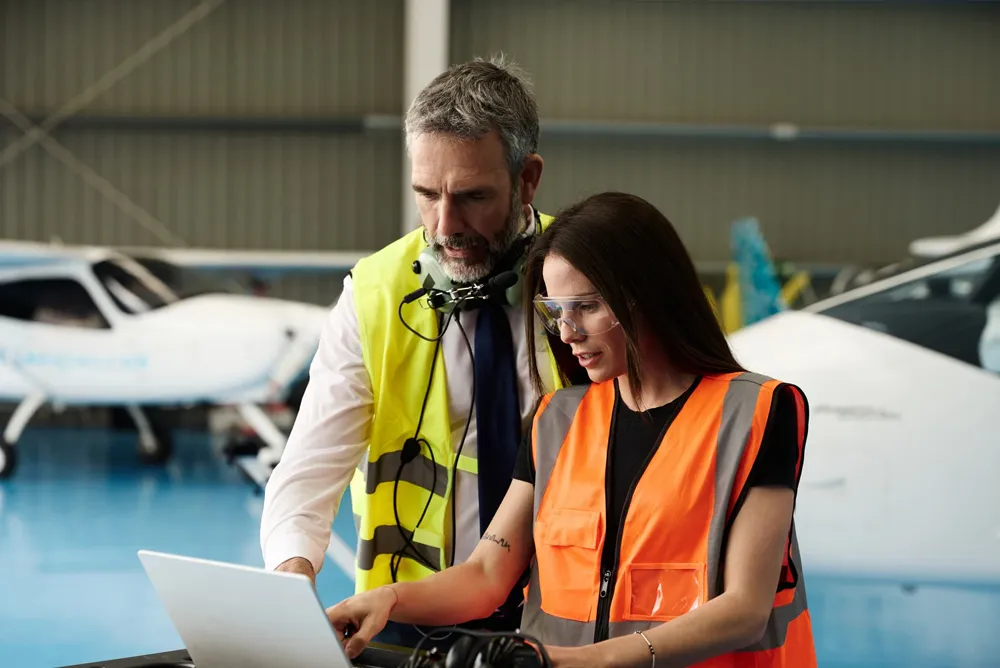 Aviation professionals coordinating aircraft management operations in a hangar